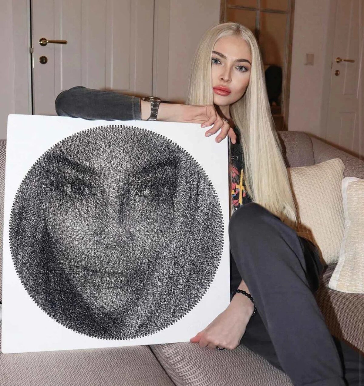 photo of a woman holding a string art portrait
